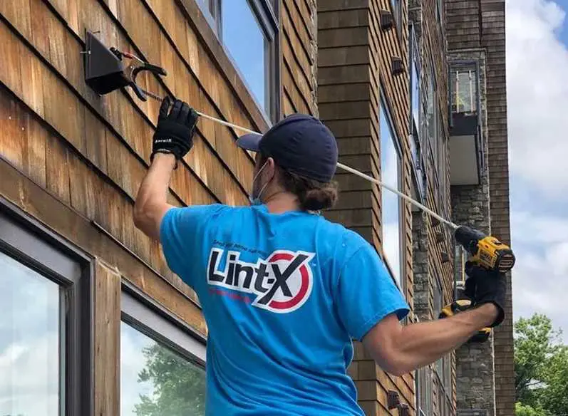 Technician Cleaning the outside of a dryer vent.